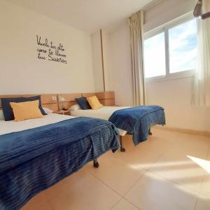 ein Schlafzimmer mit 2 Betten und ein Schild an der Wand in der Unterkunft Ayf 3 habitaciones moderno 1ª linea de playa in Oropesa del Mar