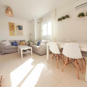 ein Wohnzimmer mit einem Sofa, einem Tisch und Stühlen in der Unterkunft Ayf 3 habitaciones moderno 1ª linea de playa in Oropesa del Mar