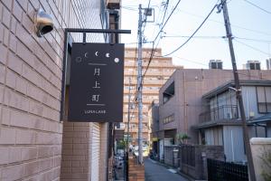 una señal en el lateral de un edificio en ZAITO Tokyo Luna Lane Inn 菊川駅から徒歩5分, en Tokio