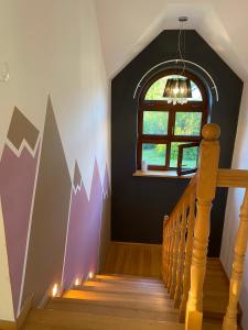 a hallway with a staircase with a window and a wall with arrows at Hostel Wilanów in Warsaw
