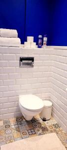 a white bathroom with a toilet and a blue wall at HomeComfort Atlantic Room in Warsaw +14 photos