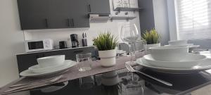 una cocina con una mesa con platos blancos y copas de vino en Alma Home Ribadesella VUT1994 AS en Ribadesella