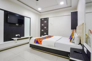 a bedroom with a bed and a flat screen tv at FabExpress Rajmahal in Navi Mumbai