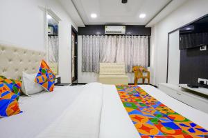 FabExpress Rajmahal في نافي مومباي: غرفة نوم مع سرير أبيض كبير في غرفة