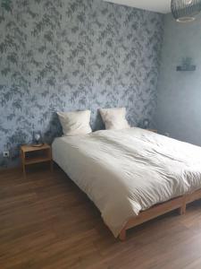 LE REFUGE في Lurcy-Lévis: غرفة نوم مع سرير كبير وورق جدران