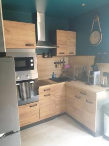 a kitchen with wooden cabinets and a stove top oven at LE REFUGE in Lurcy-Lévis