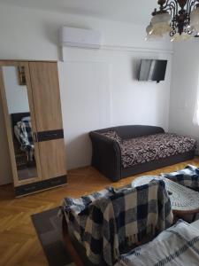 a living room with a bed and a mirror at Rita apartman in Szombathely