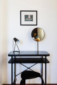 a black desk with a mirror and a chair at Casa Cervantes in Naples