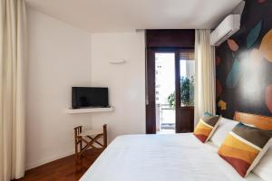 a bedroom with a bed and a tv on a wall at Casa Cervantes in Naples