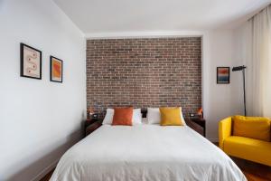 a bedroom with a bed and a brick wall at Casa Cervantes in Naples +29 photos