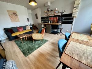 een woonkamer met een bank en een tafel bij Sur le chemin des peintres in Auvers-sur-Oise