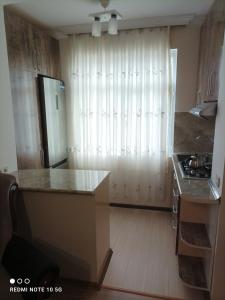 eine Küche mit einem großen Fenster und einer Küchentheke in der Unterkunft Nakhchivan Center in Nachitschewan