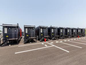 a row of black containers sitting in a parking lot at HOTEL R9 The Yard Saito in Saito