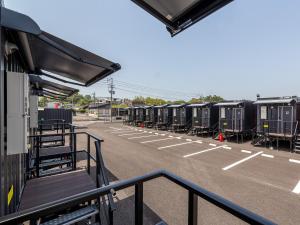 a parking lot with a row of train cars at HOTEL R9 The Yard Saito in Saito