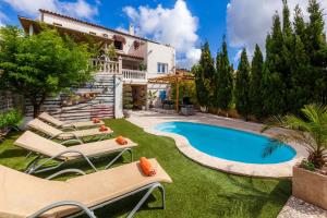 a villa with a swimming pool and lounge chairs at Casa Varna in Capdepera