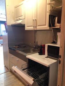 シュペール・ベスにあるAppartement Super Besseの白いキャビネット、シンク、食器洗い機付きのキッチンが備わります。
