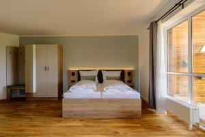 a bedroom with a bed with a large window at Landhaus Nienhagen in Ostseebad Nienhagen