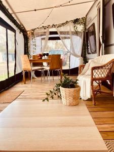 a living room with a table and chairs in a camper at Żuczkowa Przyczepa - maszoperia in Hel