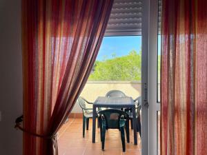 d'une table et de chaises sur un balcon avec une fenêtre. dans l'établissement Apartamento Campo de Golf, à Chiclana de la Frontera