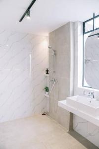 a white bathroom with a sink and a shower at Little Duck Villa - Tiny House near Gedong Putih in Lembang