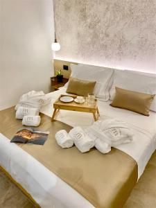 a bed with towels and a table on it at Meravigghia Suites Cefalù in Cefalù
