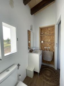 a bathroom with a toilet and a sink and a window at Ca'n Guiri, Eco Finca in Mallorca in Campanet