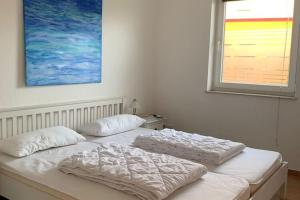 a white bed with two pillows and a window at Ferienhaus Seeadler am Vilzsee in Mirow in Mirow