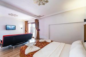 a bedroom with a large bed and a piano at Costa Bitezhan Hotel - All Inclusive in Bitez