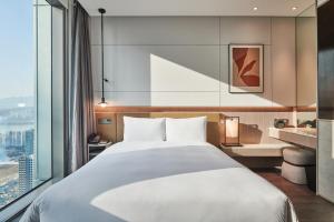 a hotel room with a large bed and a large window at Nine Tree Premier ROKAUS Hotel Seoul Yongsan in Seoul