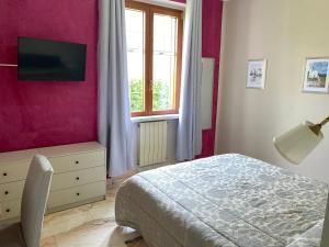 a bedroom with a bed and a tv on a wall at Villa Cecilia Bed and Breakfast in Cellole
