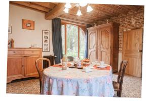 una sala da pranzo con tavolo e tovaglia; di B&B - La Cense du Pont a Bachy
