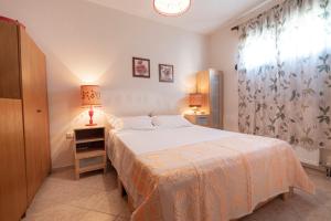 1 dormitorio con 1 cama, 2 lámparas y ventana en Zela Seaview Maisonette by RentalsPro - Kalyves Halkidiki, en Kalivia Poligirou