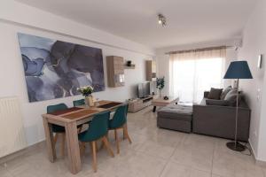 un soggiorno con tavolo, sedie e divano di Lovely 2-bedroom apartment with a city view (F10) a Pireo