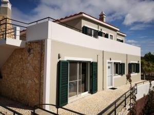 Casa blanca con persianas verdes en Casa Camé en São Bartolomeu de Messines