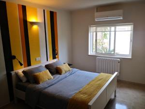 um quarto com uma cama grande e uma janela em Casa Camé em São Bartolomeu de Messines