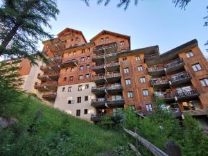 a tall building with balconies on the side of it at le hameau des ecrins in Puy-Saint-Vincent
