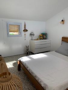 sypialnia z łóżkiem, komodą i oknem w obiekcie Villa Marquise w mieście Canet-en-Roussillon