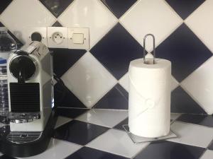 un rouleau de papier toilette sur un comptoir à côté d'un grille-pain dans l'établissement Villa L'enclos Des Lys, à Saint-Georges-dʼOléron