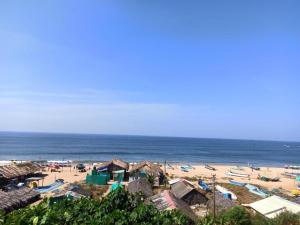 a beach with a group of buildings and the ocean at Dee Joy's Beach Place in Calangute
