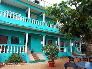 a blue building with tables and chairs in front of it at Dee Joy's Beach Place in Calangute
