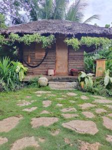 una pequeña casa con techo de hierba en Payag n' Kapitan, Experience pinubre living, en Siquijor