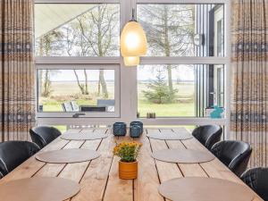 Mosevråにある6 person holiday home in Oksb lの大きな木製テーブル(椅子付)、大きな窓