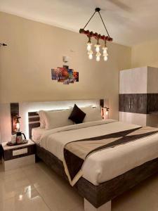 a bedroom with a large bed and a chandelier at Ponmari Villa in Ooty