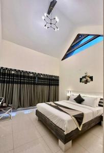 Un dormitorio con una cama grande y una ventana en Ponmari Villa, en Ooty