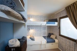 リッチョーネにあるClub del Sole Romagna Family Resortの二段ベッド2台、窓が備わる小さな客室です。