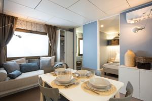 a living room with a table and a couch at Romagna Family Village Riccione in Riccione