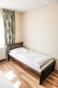 1 dormitorio con 1 cama en una habitación con ventana en Hunor Hotel és Étterem, en Vásárosnamény