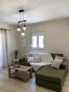 een woonkamer met een groene bank en een tafel bij Atalia Apartment, Orne Crete in Orné