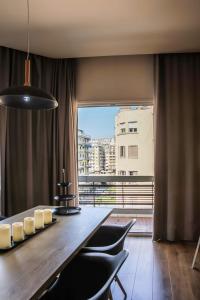 テッサロニキにあるSuperior One Luxury Apartmentsのダイニングルーム(テーブル、椅子付)、大きな窓が備わります。