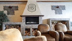a living room with two chairs and a fireplace at Hotel lo Stambecco in Breuil-Cervinia